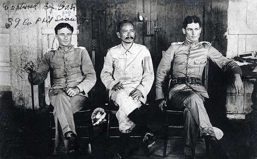 General Vicente Lukbán, center, who led the revolution on the islands of Samar and Leyte. He is seated with 1st Lt. Alphonse Strebler, 39th Philippine Scouts, and 2nd Lt. Ray Hoover, 35th Philippine Scouts. Image in the public domain from the Library of Congress, scanned by Scott Slaten.